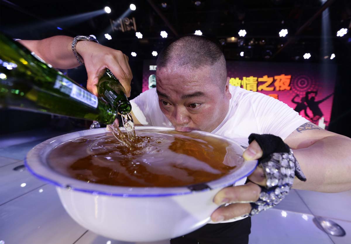 A singer drinks from a huge bowl of beer on-stage as he pays tribute to customers after performing at an entertainment club in Beijing in May.
