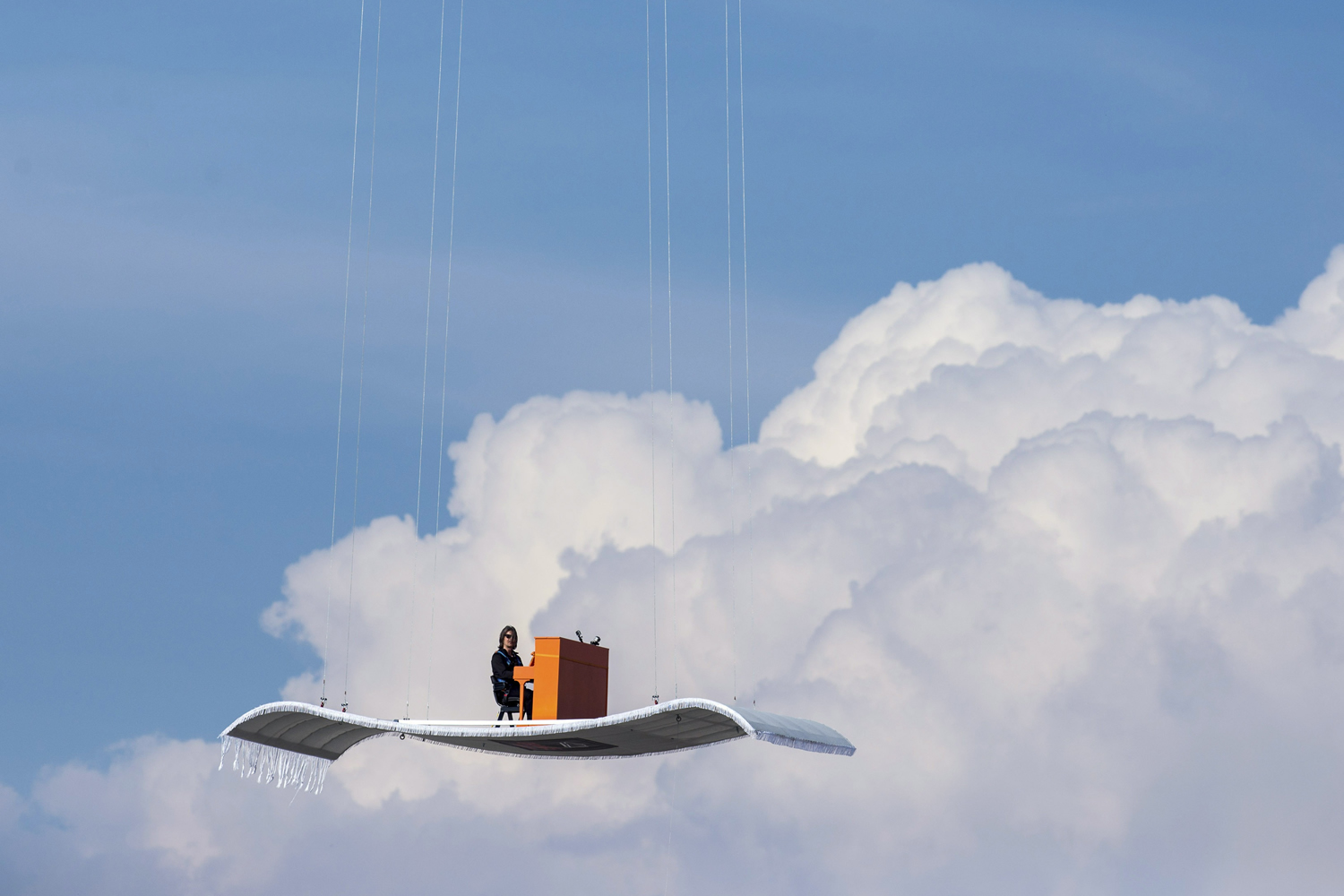 German pianist Stefan Aaron plays an orange piano on a "flying carpet" platform suspended from a helicopter, over the Munich airport in Germany on July 23. The concert is the fourth station of the "Orange Piano Tour", which brings the artist to places around the world.