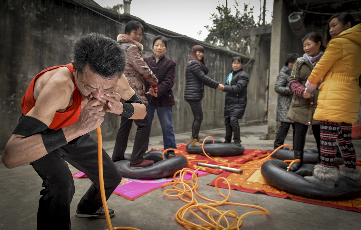 Nie Yongbing inflates tires using his nose as people stand on them in Chengdu, China. Nie inflated four tires bearing the weight of eight adults in 21 minutes during a performance at his home. A traditional Chinese doctor had suggested Nie practice blowing balloons with his nose to improve his health.