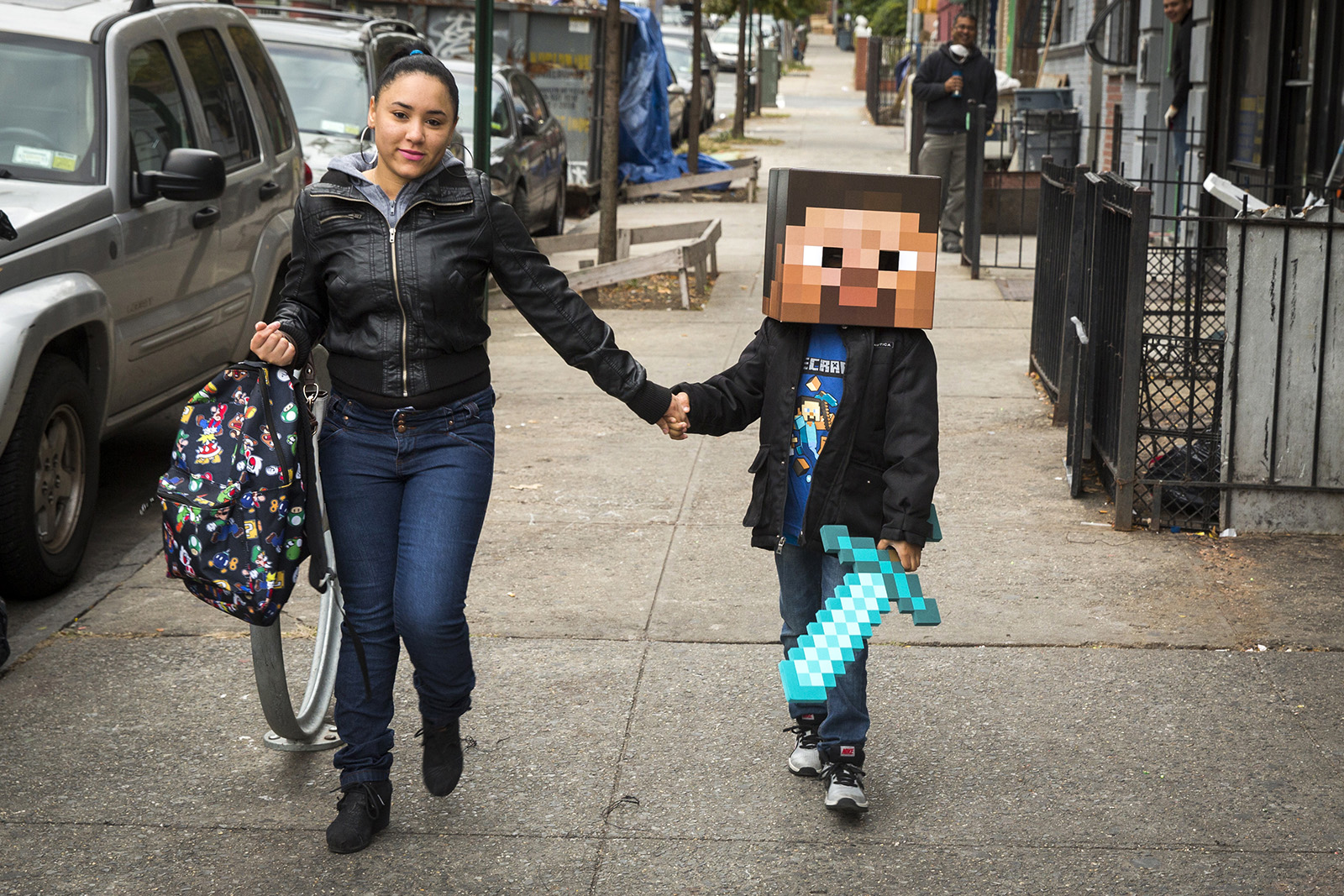A woman walks her child to school as he is dressed as a character from Minecraft in New York on Oct. 31.