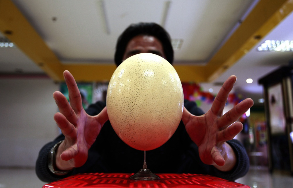 Cui Juguo, a 50-year-old security guard, balances an ostrich egg on a needle in Changsha, China on Dec. 10. Cui has practiced balancing eggs on needles for over 6 years.
