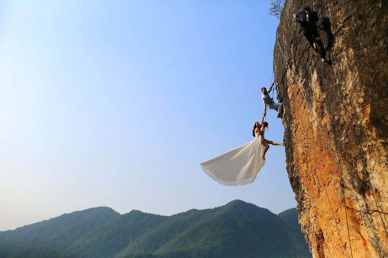 Zheng Feng, an amateur climber takes wedding pictures with his bride on a cliff in Jinhua, China.