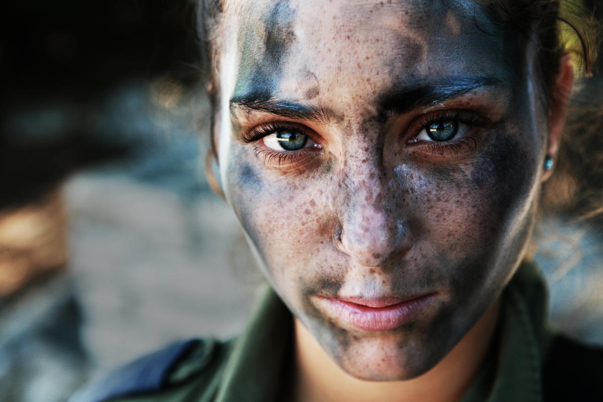 AN 18 YEAR OLD IDF SOLDIER PAUSES AFTER A LONG RUN IN FULL GEAR AND BATTLE PAINT. BY ASHER SVIDENSKY