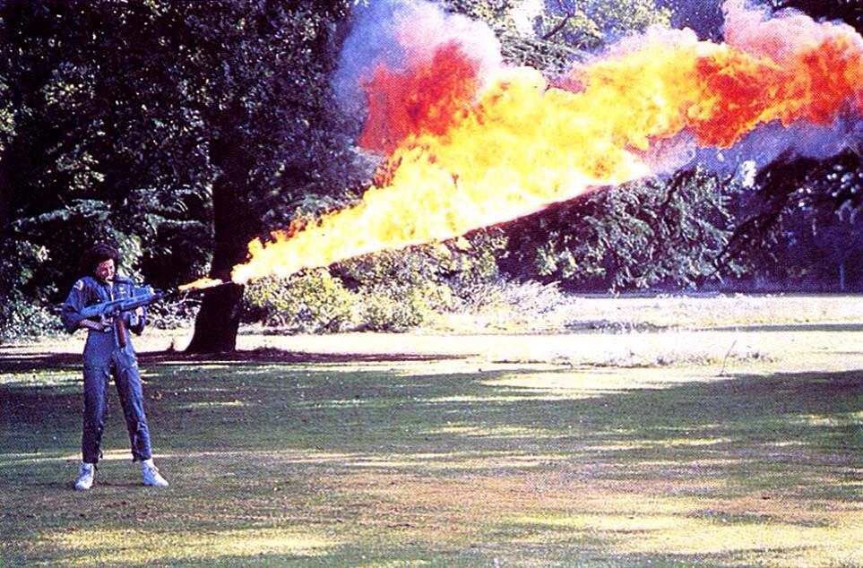 Sigourney Weaver tests out the flame-thrower prior to filming "Alien" on the Shepperton Studios' backlot lawn, 1978. A remote switch was used to activate the lighter inside, and once lit, director Ridley Scott "liked to keep it that way."