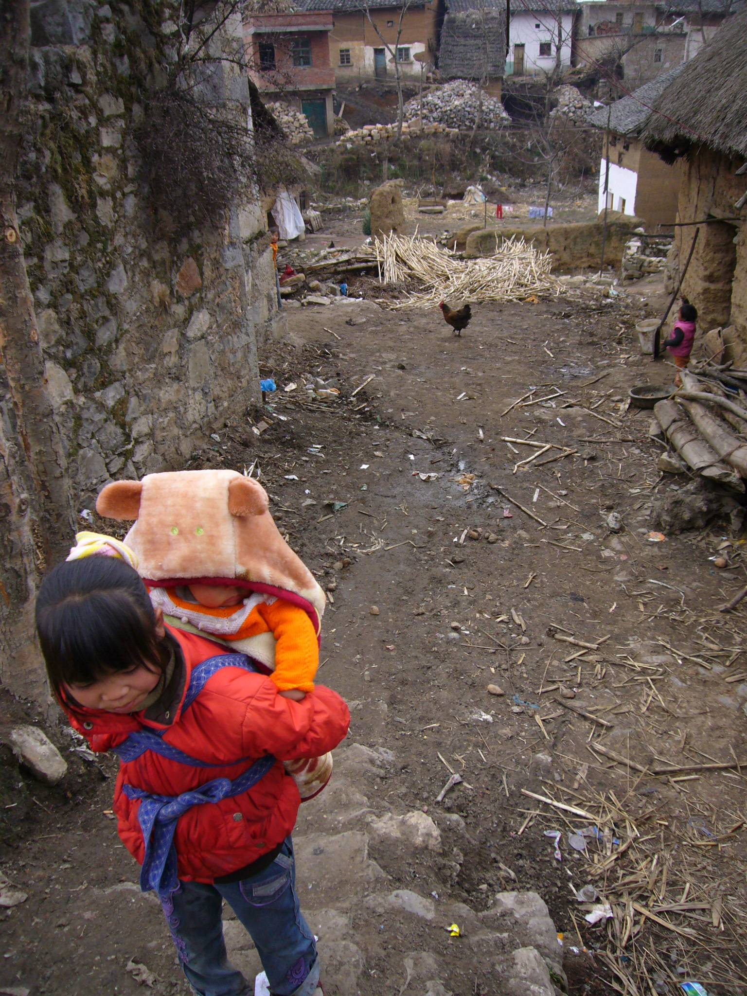 Young rural Chinese daughters carry the burden of their infant siblings while their parents work.