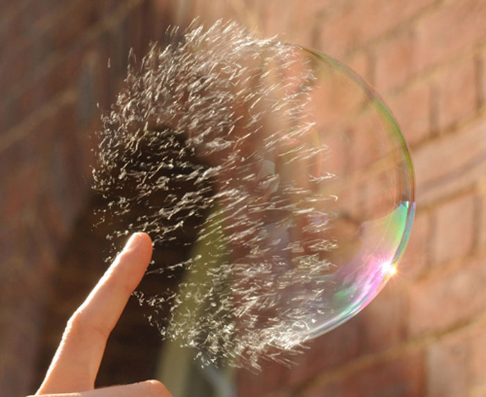 Popping a soap bubble