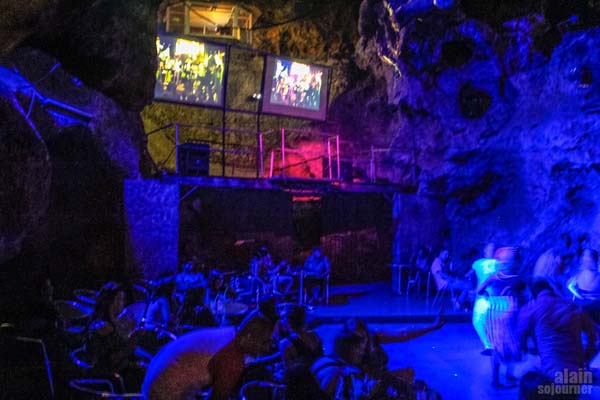 The disco is spread out in the cave, you can see the DJ booth here and video screens.