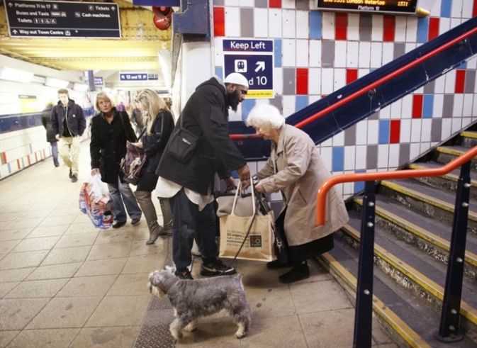 This man stopped to help a woman with her bags even though he was trying to catch the train.