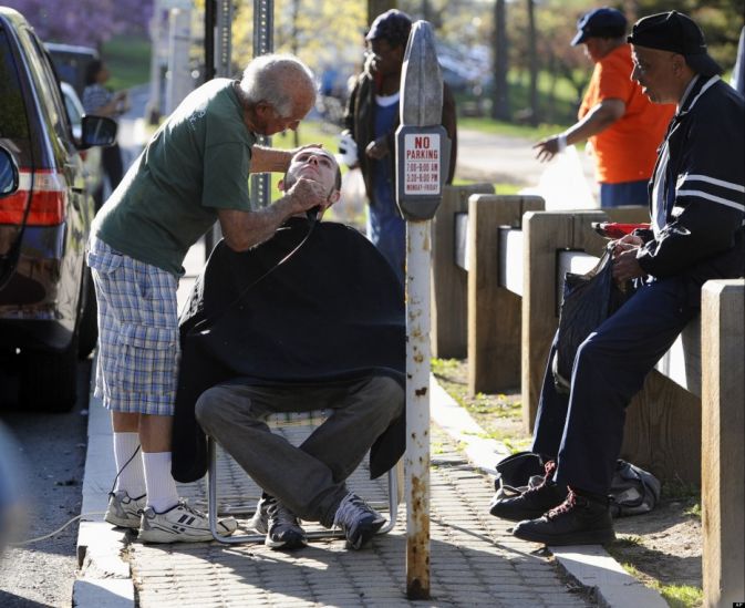82 year old barber does his job at local park...