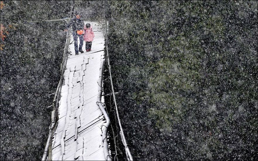 Dangerous path through the broken bridge, covered with snow, in the Chinese province of Sichuan.