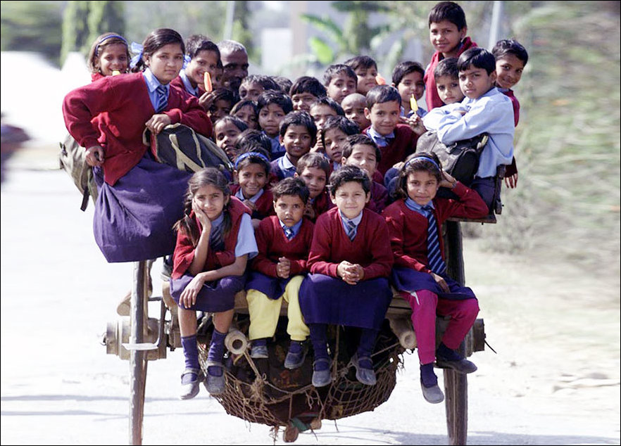 Pupils traveling by rickshaw in New Delhi, India.