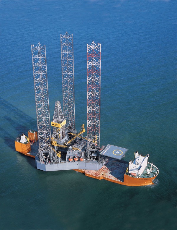 These are drilling rigs with a gridwork of iron below them creating a giant footprint to stabilize the weight. They jack up out of the water with those large legs.