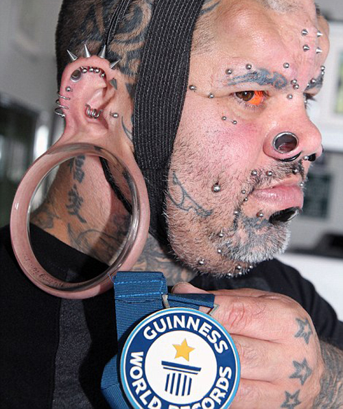A Hawaiian man has claimed the Guinness World Record for the largest non-surgically made stretch earlobes - which are so big you can fit a hand through them.