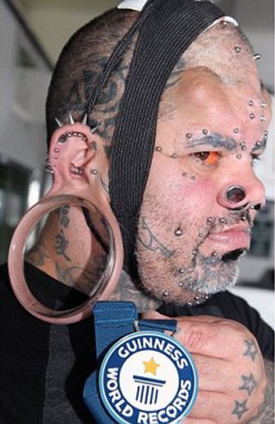 Along with his flesh tunnels, he has had silicon horns implanted on his head, stretches in his nostrils, tattooed eyebrows and studs all over his face.