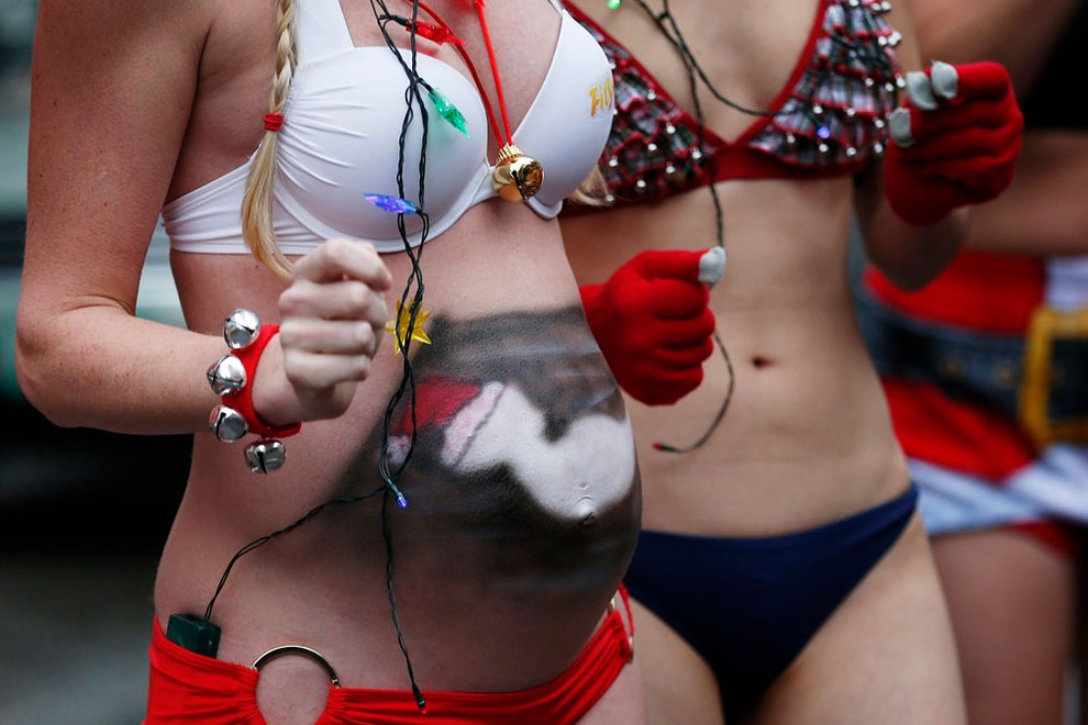 A pregnant woman with a painted stomach participates in the 15th annual Santa Speedo Run through the streets of Boston.