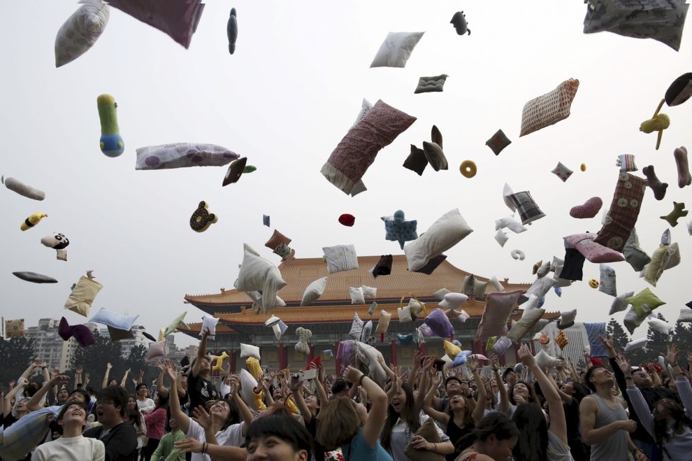 Participants throw their pillows during the International Pillow Fight Day at Liberty Square, in Taipei, Taiwan