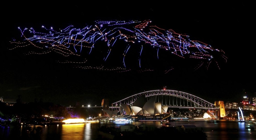 An aerial performance featuring 100 illuminated drones fly above the Sydney Harbour Bridge and Opera House during the Vivid Sydney light festival in Sydney