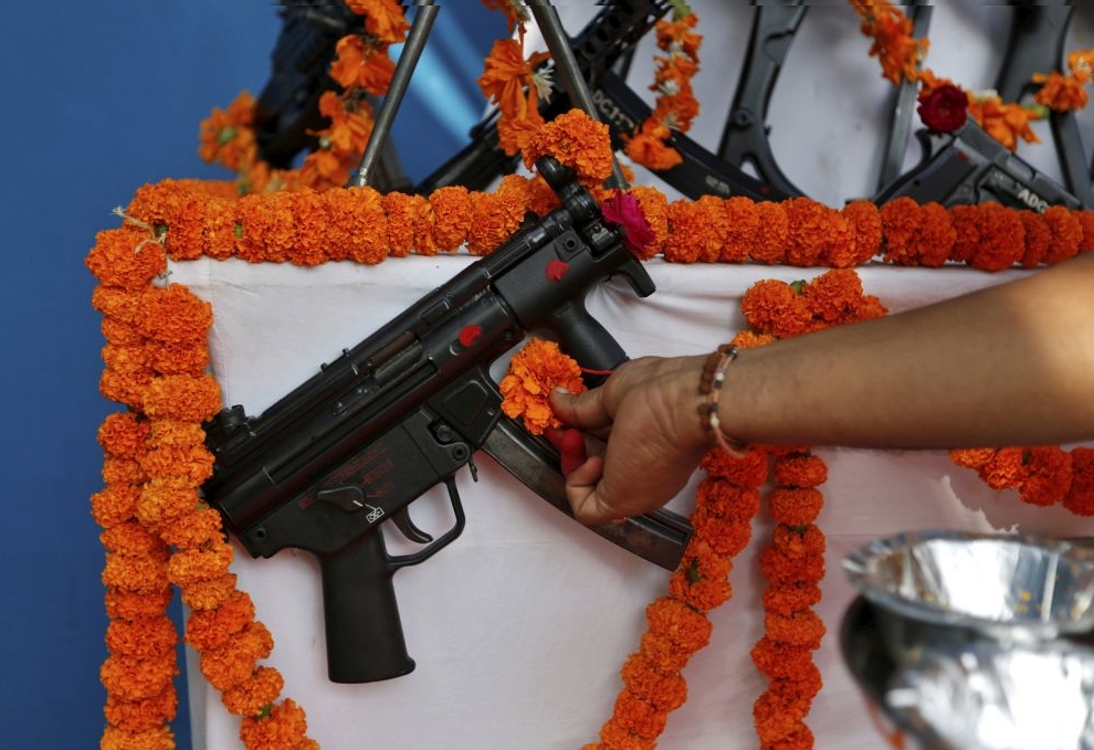 A Hindu priest offers prayers to a weapon as part of a ritual at the police headquarters on the occasion of Vijaya Dashmi or Dussehra festival in Ahmedabad