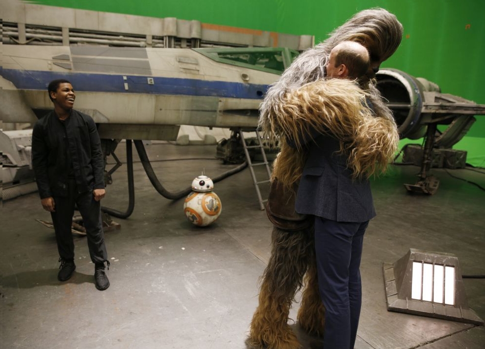Britain's Prince William is hugged by Chewbacca as British actor John Boyega smiles during a tour of the Star Wars sets at Pinewood studios in Iver Heath, west of London