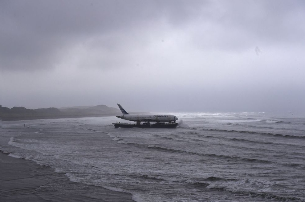 Bad weather surrounds a Boeing 767 airplane as it arrives onto Enniscrone beach after it was tugged from Shannon airport out to sea around the west coast of Ireland