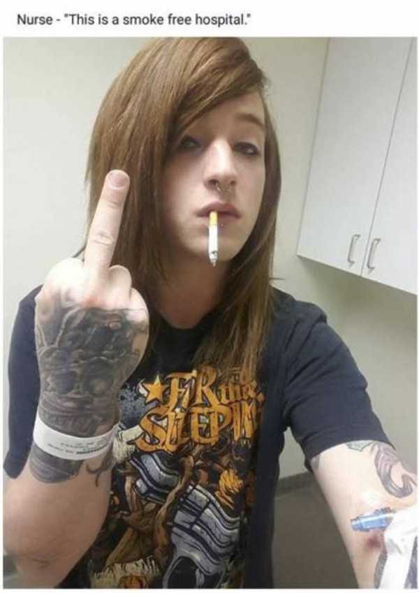 Girl with tattoos on her hand flipping off the camera in reference to the nurse at the hospital that said there is no smoking here.