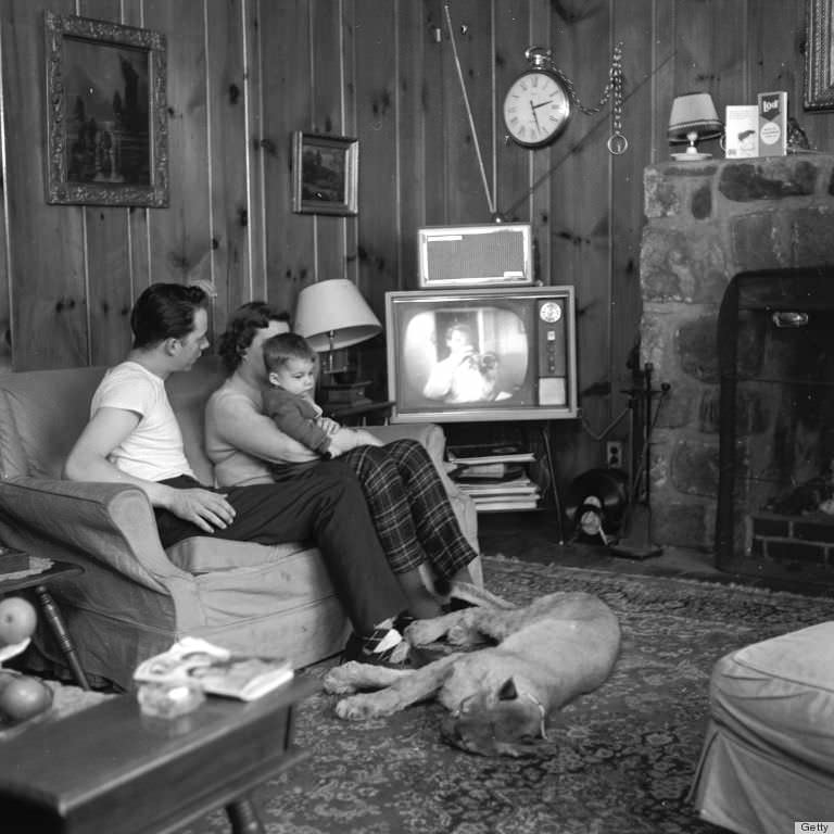 A family is watching TV with their pet puma on the floor in 1952.