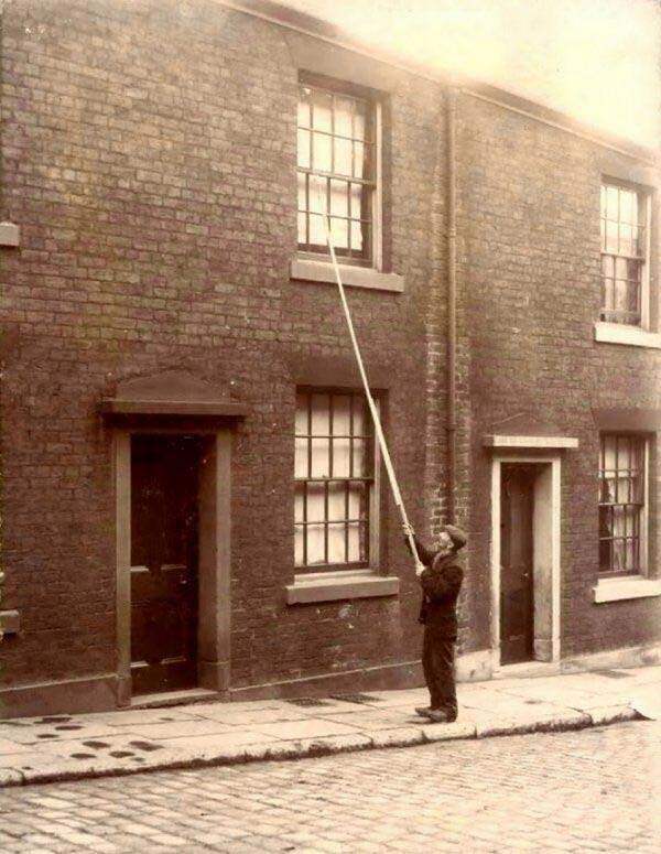 A man known as a knocker wakes up his clients somewhere in England in 1924.