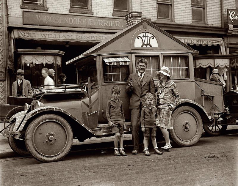 A family stands in front of their modified car turned into an early camper as they drive around the US in 1924.