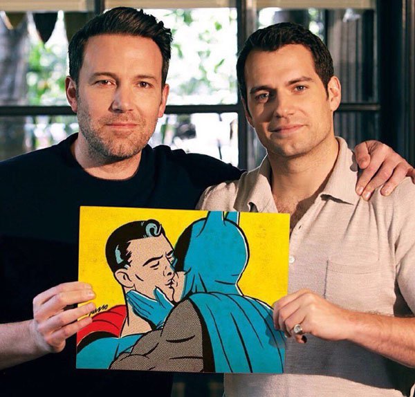 Random pic of Ben Affleck holding a picture of superman making out with batman