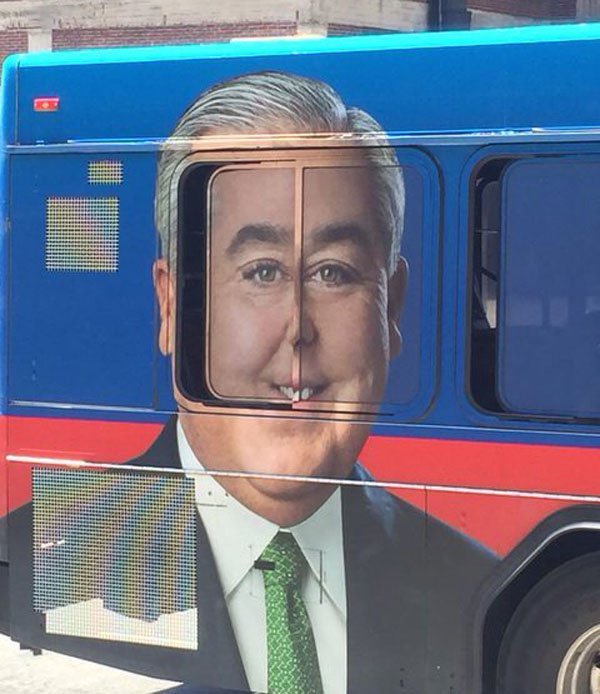 Ad on a bus wrap that looks hilarious with one of the windows open a crack to make him look a bit bucktoothed.