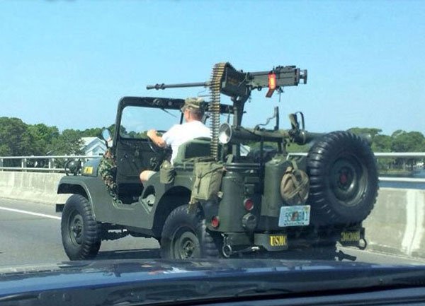 Jeep on the road with massive gun loaded up top.