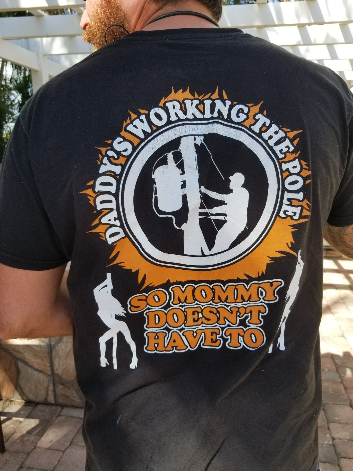Pic of man wearing shirt that says Daddy's working the pole so mommy don't have to.