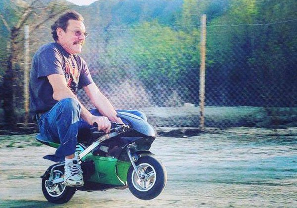 Full grown man riding a pocket rocket motorcycle