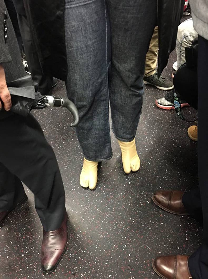 funny picture of someone on the subway wearing boots that are glove like when it comes to the big toe