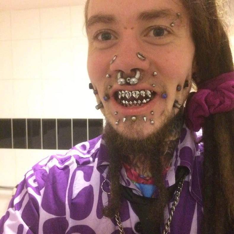 crazy picture of man with symmetrical large amount of piercings