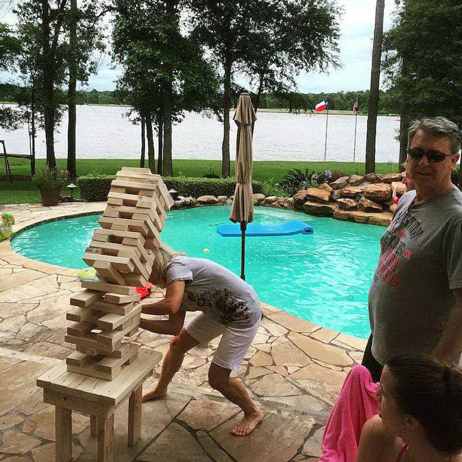 perfectly timed photo of Jenga falling on a kid as he pulls out a piece by the pool