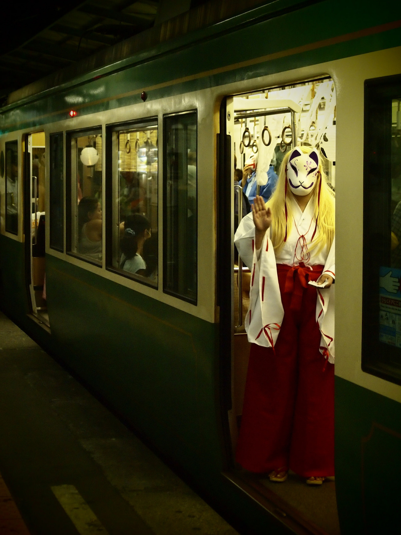 woman dressed as a cat waiving from the subway