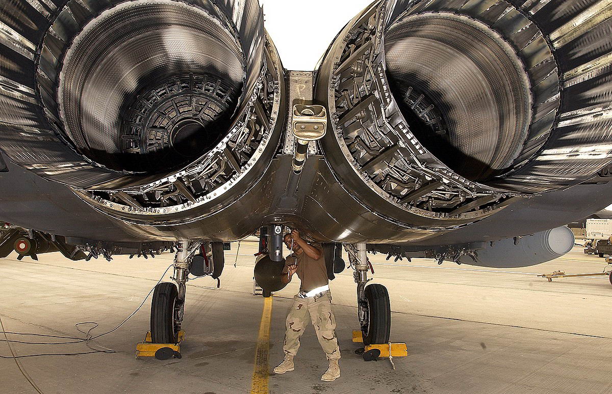 man standing under massive jet engines