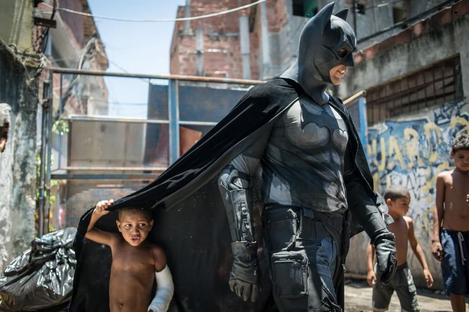 Children play around a man disguised as Batman at the Favela do Metro slum, area just near the Maracana stadium, in Rio de Janeiro, Brazil.