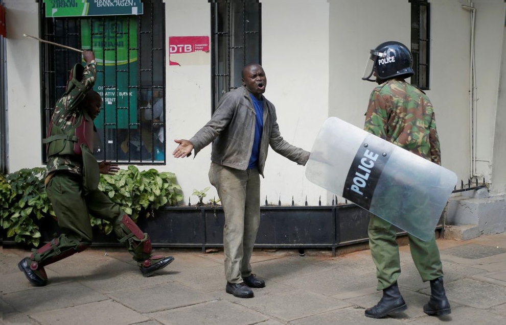 Kenyan policemen beat a protester during clashes in Nairobi, Kenya