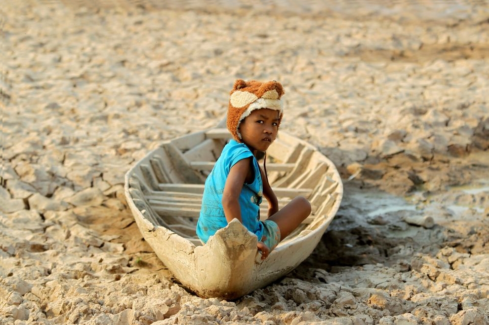 A girl sits on her boat at a Bak Angrout dried up pond at the drought-hit Kandal province in Cambodia