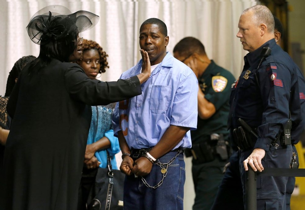 An inmate with the Louisiana Department of Corrections is consoled by friends and family they attend the funeral of Alton Sterling, in Baton Rouge