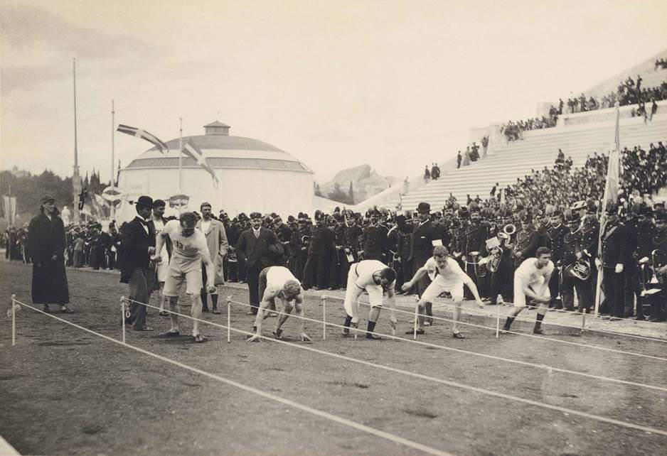 Runners prepare to run the 100m dash at the first modern Olympic Games in Athens, Greece in 1896. American Thomas Burke (second from left) would win gold finishing first at around 12 seconds. Only 14 nations participated; Australia, Austria, Bulgaria, Chile, Denmark, France, Germany, Great Britain, Greece, Hungary, Italy, Sweden, Switzerland and the US. The US took the most golds, at 11, while the home country Greece took the most medals at 46. Most athletes paid for everything themselves, as Olympic programs didn't exist. 241 total athletes competed in a total of 43 events over 9 days.
