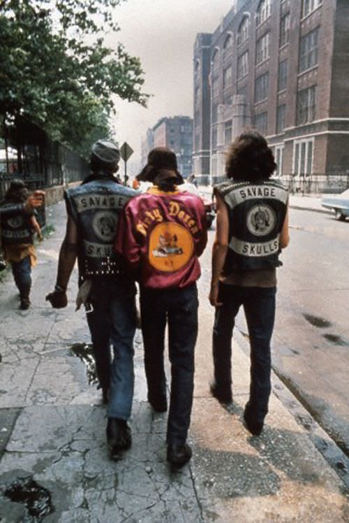 3 Gang members walk the streets of New York City, US in 1972. Gangs were a part of NYC since pretty much the beginning, as groups would fight for control of streets and certain trades. The 1970s brought gangs into colorful ensembles that were easy to spot, making their presence felt. The film The Warriors is a great example of this as they used real gangs for security and costume design for the ones features in the film.