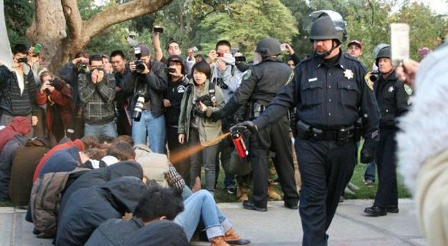 A police officer pepper-sprays Occupy protesters at the University of California