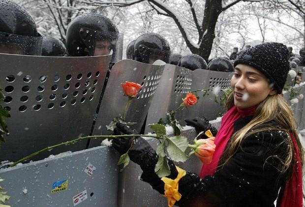 A Ukrainian woman places carnations into shields of anti-riot policemen outside the presidential office in Kiev. Ukraine