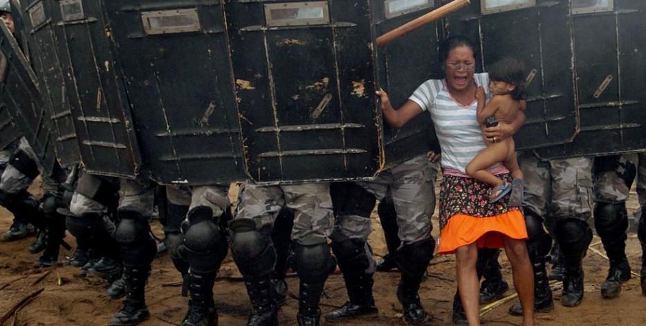 An indigenous woman holds her child while trying to resist the advance of Amazonas state policemen in Manaus