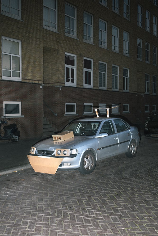 This Guy Walks The Streets At Night Pimping Strangers’ Rides… With Cardboard