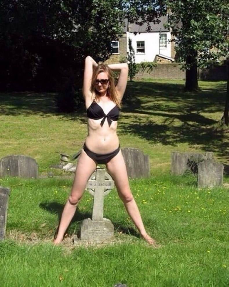 Woman in a bikini over someone's grave stone.