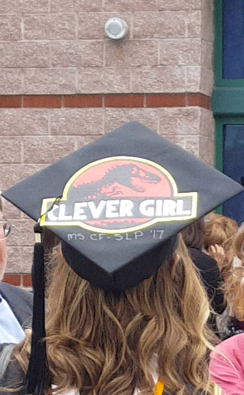 Graduation cap that says Clever Girl in the font of Jurassic Park.